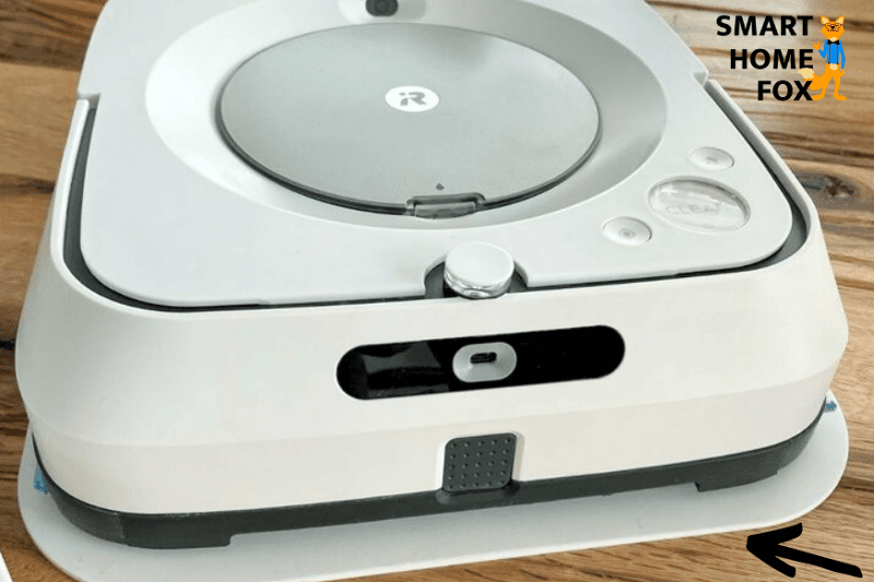 Моющий робот стоит на пластиковом коврике во время зарядки аккумулятора